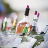 Plusieurs bouteilles de vin, dont du rosé, sont placées dans un seau à glace pour garder le vin au frais à table.