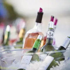 Plusieurs bouteilles de vin, dont du rosé, sont placées dans un seau à glace pour garder le vin au frais à table.