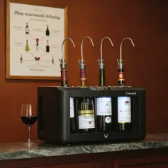 Système de conservation de vin avec quatre bouteilles ouvertes, un verre de vin rouge à côté. Le tableau temps de garde des vins au mur donne des conseils.