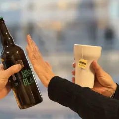 Une main repousse une bouteille de bière, l'autre tient une tasse de thé Earl Grey. Un choix pour un cocktail sans rhum.