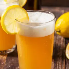 Deux verres de bière citron, rafraîchissante et pétillante, ornés de rondelles de citron. Un nom parfait pour cette boisson !