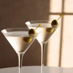 Deux dry martini glacés, décorés d'olives vertes, prêts à être dégustés. Une recette simple pour un cocktail parfait.