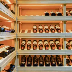 Étagères en bois remplies de bouteilles de vin. Une belle cave à vin pour bien choisir.