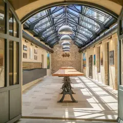 L'intérieur lumineux de la Maison Champy, avec son toit de verre, ses tables en bois et ses murs en pierre, invite à la dégustation.