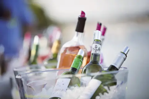 Plusieurs bouteilles de vin, dont du rosé, sont placées dans un seau à glace pour garder le vin au frais à table.