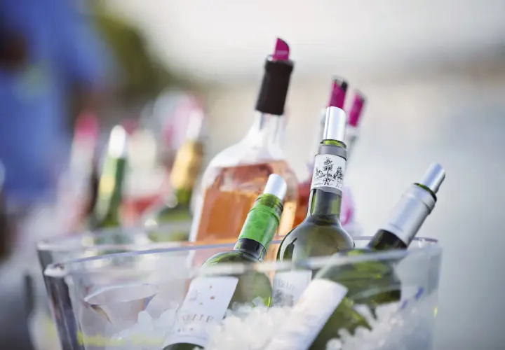 Plusieurs bouteilles de vin, dont du rosé, sont placées dans un seau à glace pour garder le vin au frais à table.