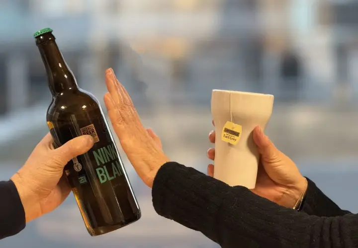 Une main repousse une bouteille de bière, l'autre tient une tasse de thé Earl Grey. Un choix pour un cocktail sans rhum.