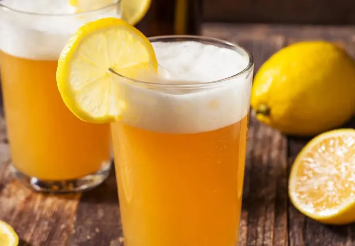 Deux verres de bière citron, rafraîchissante et pétillante, ornés de rondelles de citron. Un nom parfait pour cette boisson !
