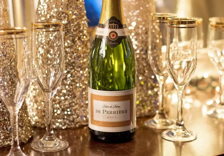 Une bouteille de champagne De Perriere et des coupes champagne sein, prêtes pour une célébration étincelante.
