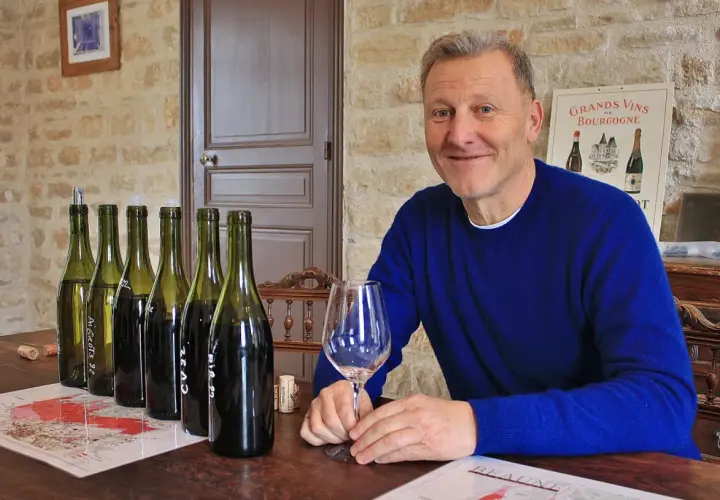 Pierre Jean Villa, vigneron souriant, présente une dégustation de vins. Bouteilles alignées, verre à la main, il partage sa passion.