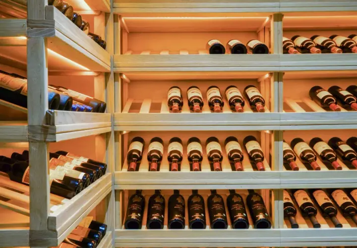 Étagères en bois remplies de bouteilles de vin. Une belle cave à vin pour bien choisir.