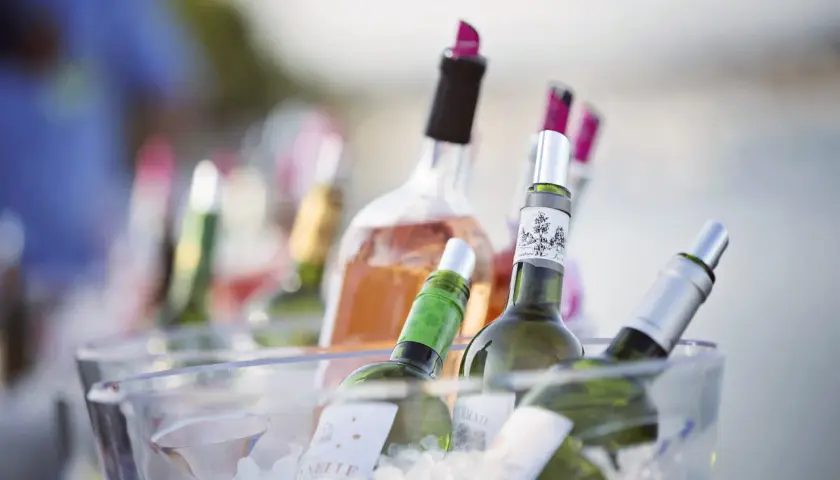 Plusieurs bouteilles de vin, dont du rosé, sont placées dans un seau à glace pour garder le vin au frais à table.