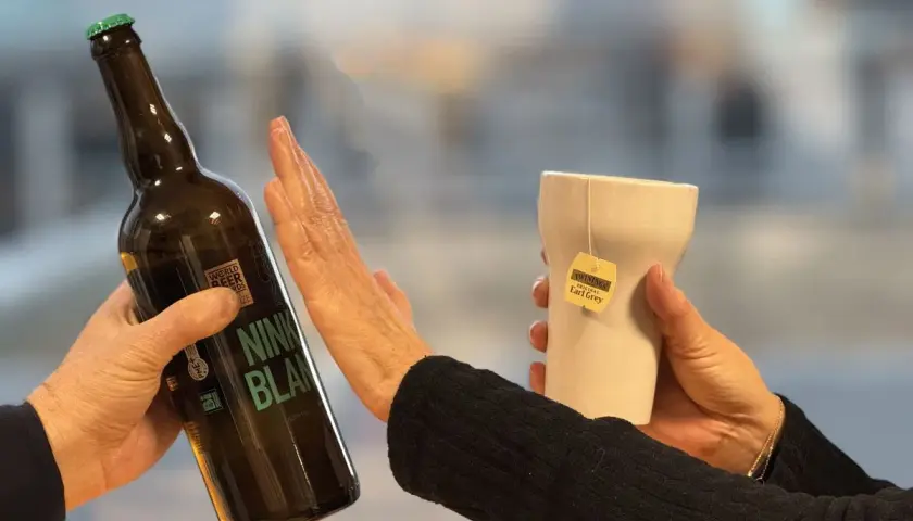 Une main repousse une bouteille de bière, l'autre tient une tasse de thé Earl Grey. Un choix pour un cocktail sans rhum.
