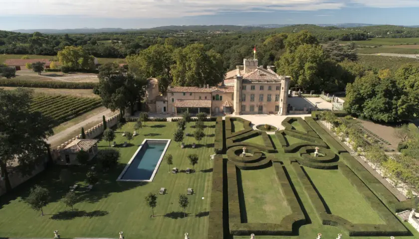 Vue aérienne du **château Beaulieu**, un domaine viticole pittoresque, avec ses jardins à la française, sa piscine et ses vignobles.