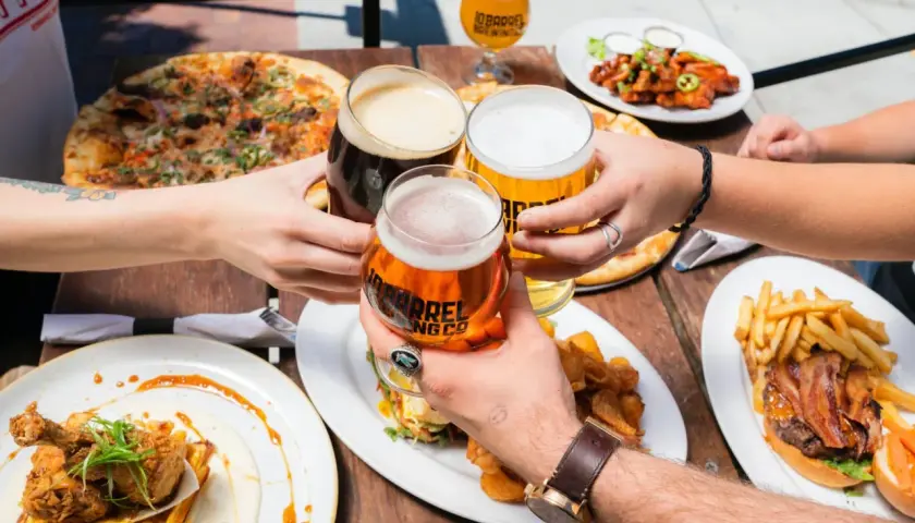 Un toast entre amis avec des bières à 11 degrés, pizza, burger et poulet frit.