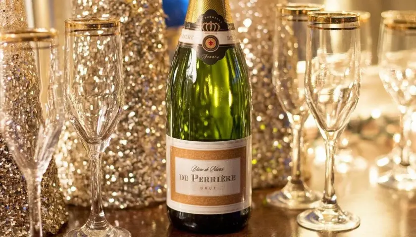 Une bouteille de champagne De Perriere et des coupes champagne sein, prêtes pour une célébration étincelante.