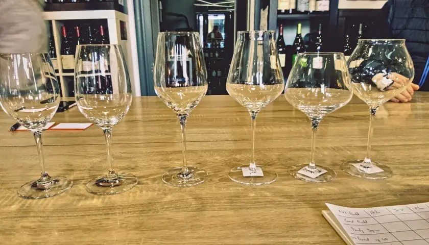 Six verres à pied, prêts pour une dégustation. La contenance d'un verre ballon est idéale pour apprécier les arômes.