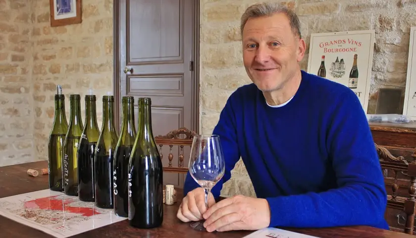 Pierre Jean Villa, vigneron souriant, présente une dégustation de vins. Bouteilles alignées, verre à la main, il partage sa passion.