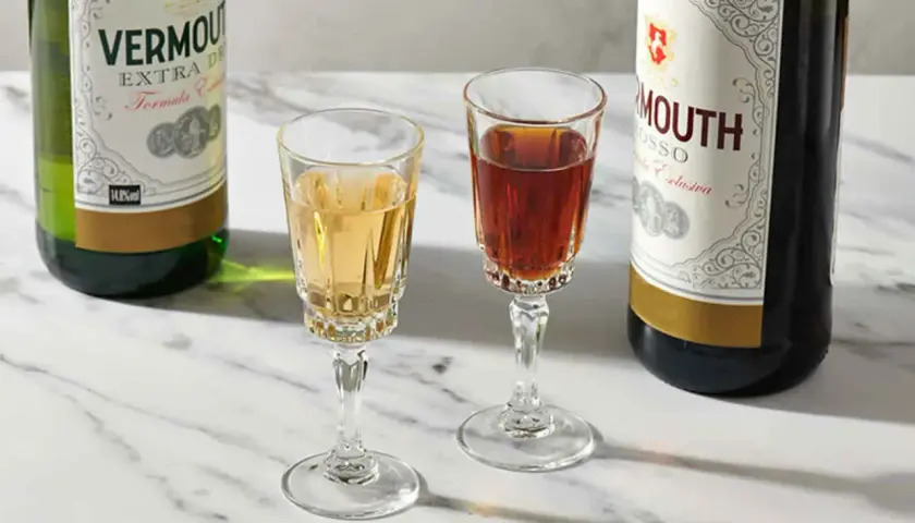 Deux verres de vermouth blanc et rouge, accompagnés de leurs bouteilles. Un apéritif raffiné.