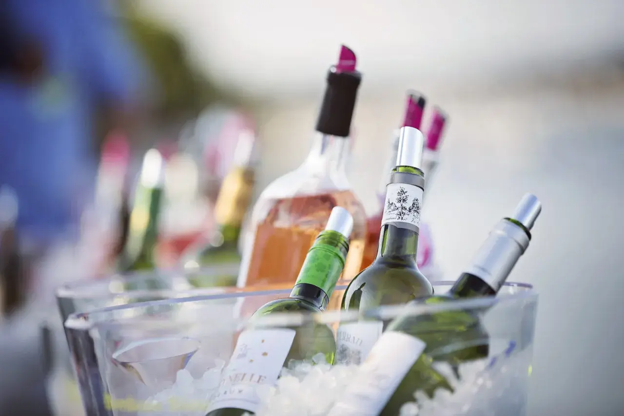 Plusieurs bouteilles de vin, dont du rosé, sont placées dans un seau à glace pour garder le vin au frais à table.