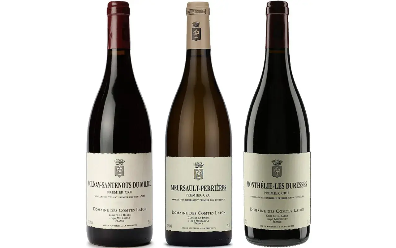 Trois bouteilles de vin du domaine des Comtes Lafon : Volnay-Santenots, Meursault-Perrières et Monthelie-Les Duresses.