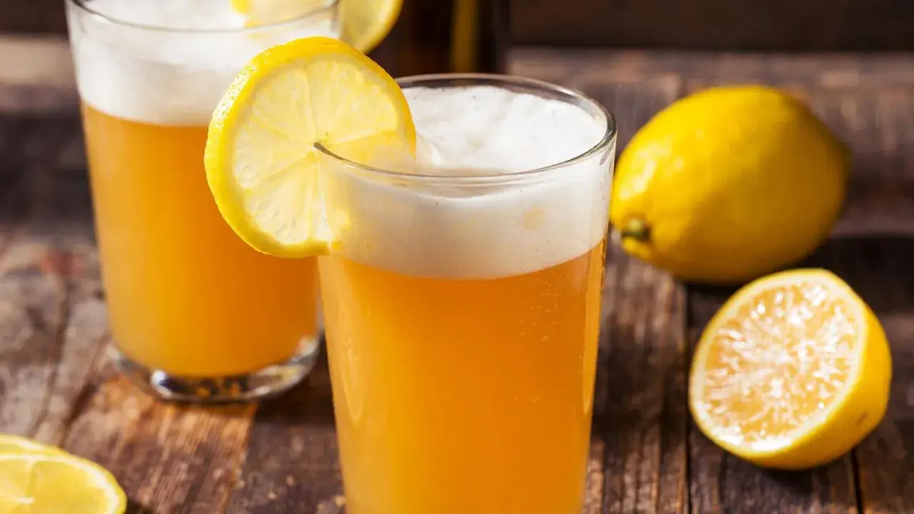 Deux verres de bière citron, rafraîchissante et pétillante, ornés de rondelles de citron. Un nom parfait pour cette boisson !