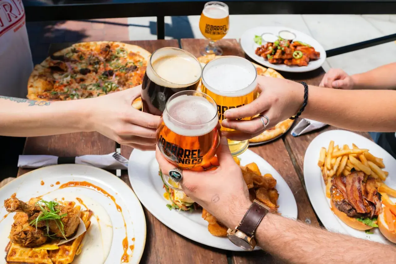 Un toast entre amis avec des bières à 11 degrés, pizza, burger et poulet frit.
