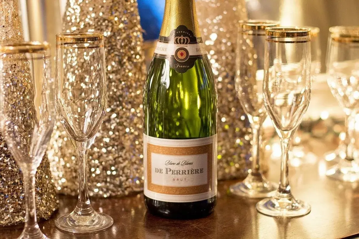 Une bouteille de champagne De Perriere et des coupes champagne sein, prêtes pour une célébration étincelante.