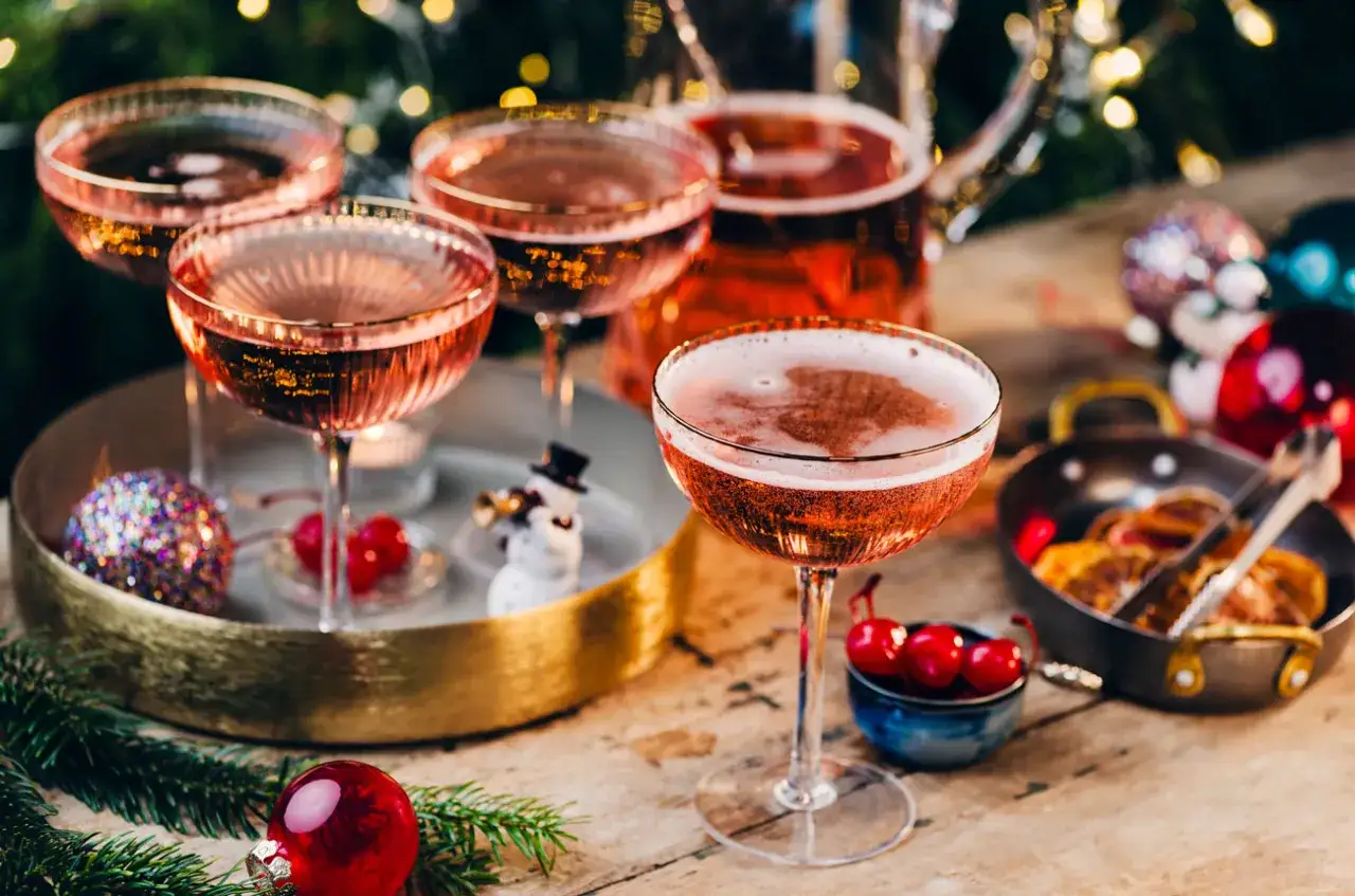 Des coupes de champagne rose p&eacute;tillant, le meilleur cocktail mousseux pour les f&ecirc;tes, avec des d&eacute;corations festives.
