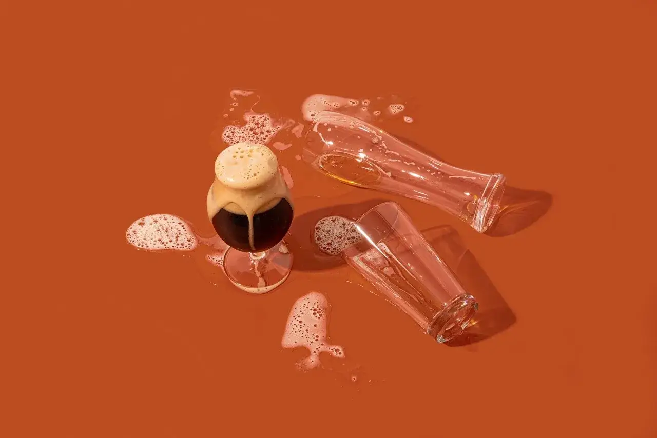 Verre de bi&egrave;re brune renvers&eacute;, deux verres vides &agrave; c&ocirc;t&eacute;. Une sc&egrave;ne qui &eacute;voque une allergie &agrave; la bi&egrave;re.