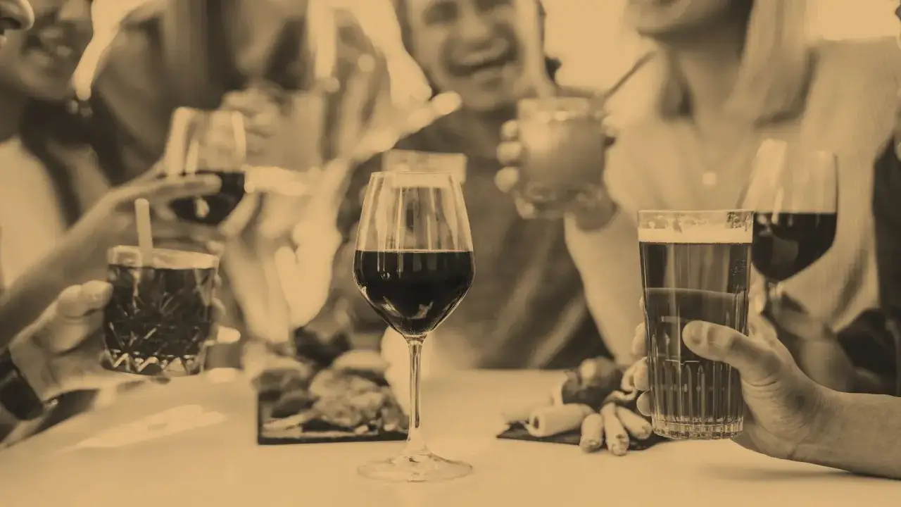 Des amis trinquent joyeusement. Combien de temps pour éliminer une bouteille de vin ? La soirée s'annonce longue et festive.