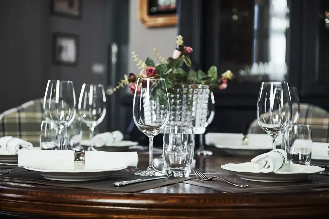 Disposition &eacute;l&eacute;gante de verres &agrave; vin et &agrave; eau sur une table dress&eacute;e, pr&ecirc;te pour un repas raffin&eacute;.