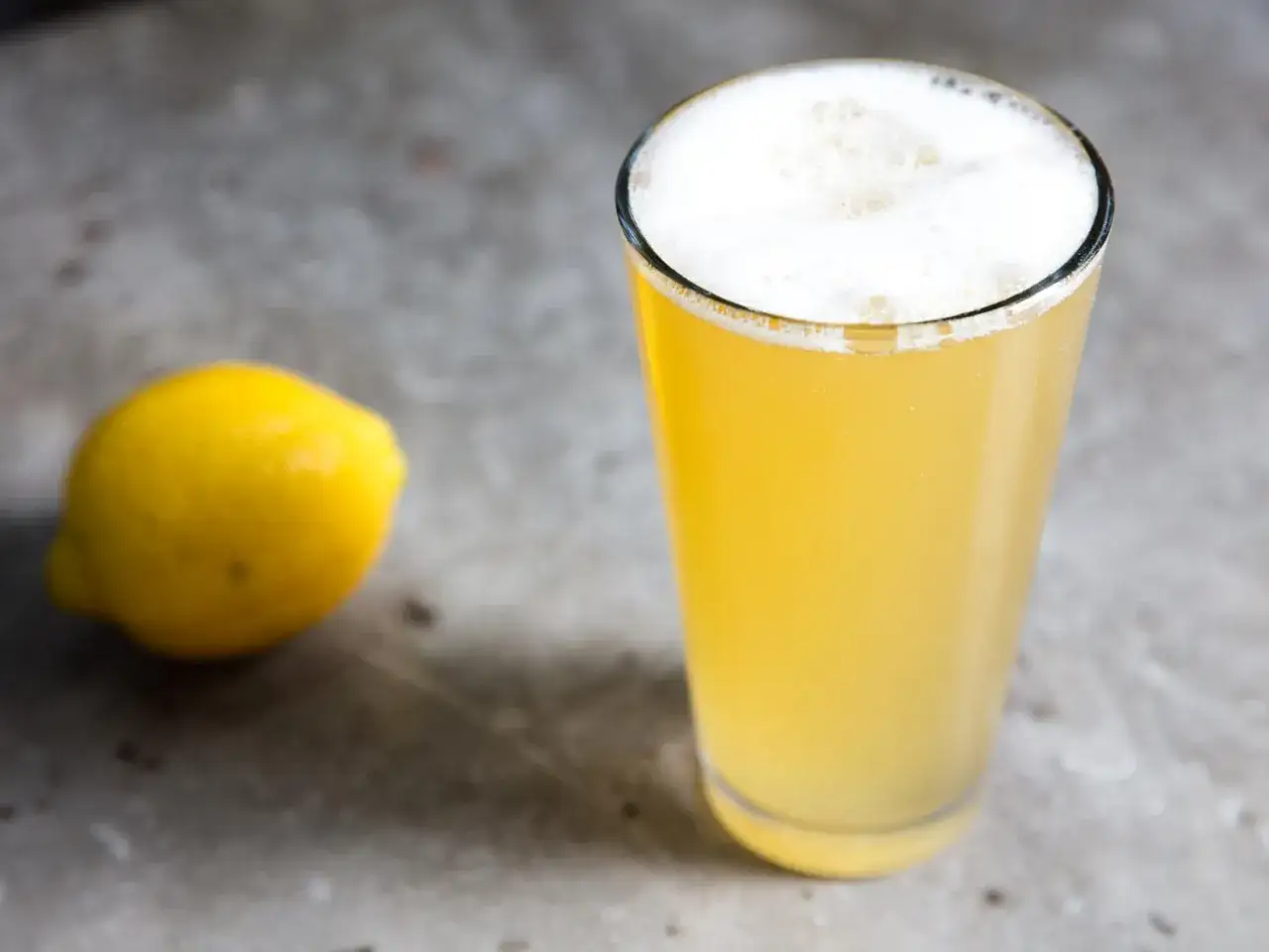 Un verre de bi&egrave;re citronn&eacute;e p&eacute;tillante, avec un citron jaune &agrave; c&ocirc;t&eacute;. Parfait pour un twist rafra&icirc;chissant !