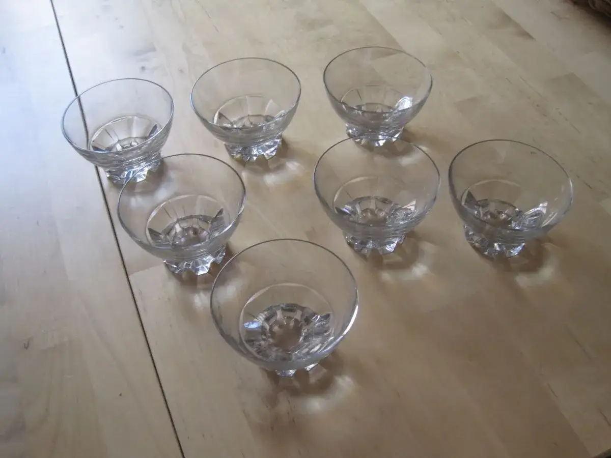 Sept verres &agrave; pied en cristal, forme coupe, pr&ecirc;ts pour une d&eacute;gustation de champagne ou un dessert.