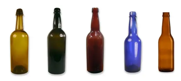 Cinq bouteilles de différentes couleurs et tailles, dont une bouteille de bière ambrée, alignées sur fond blanc.